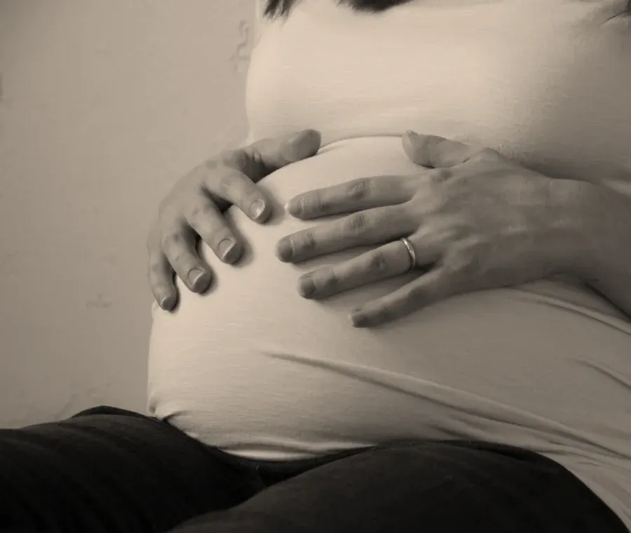 Femme enceinte, les mains posées sur son ventre arrondi